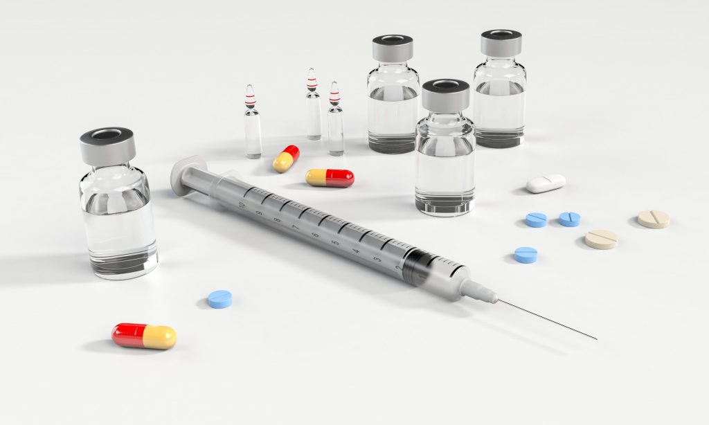 needles and pills with medication vials