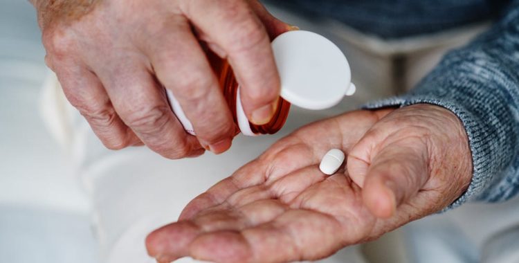 man dumping pill into hand