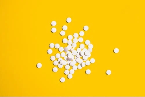 white pills on a yellow surface
