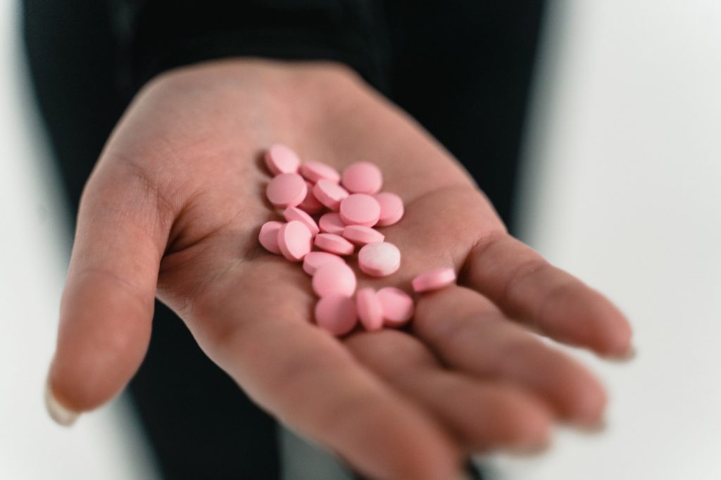 A person with a handful of meds