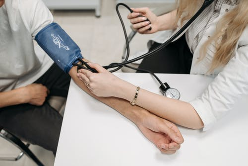 A doctor checking a patient’s blood pressure levels