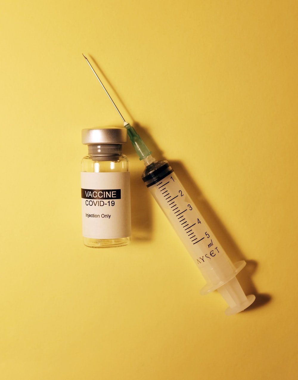 a COVID-19 vaccine bottle and a syringe