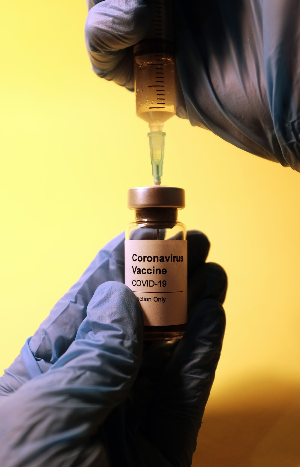 a COVID-19 vaccine bottle and a syringe