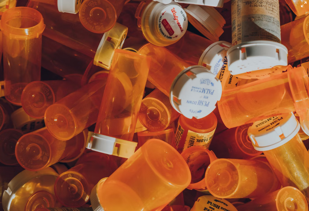 A bunch of orange pills containers stacked