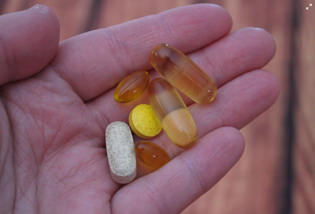  a person holding capsules in each hand