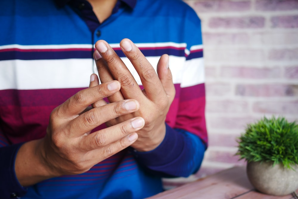 Person holding painful finger joints