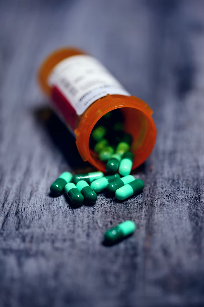 an orange bottle with green pills