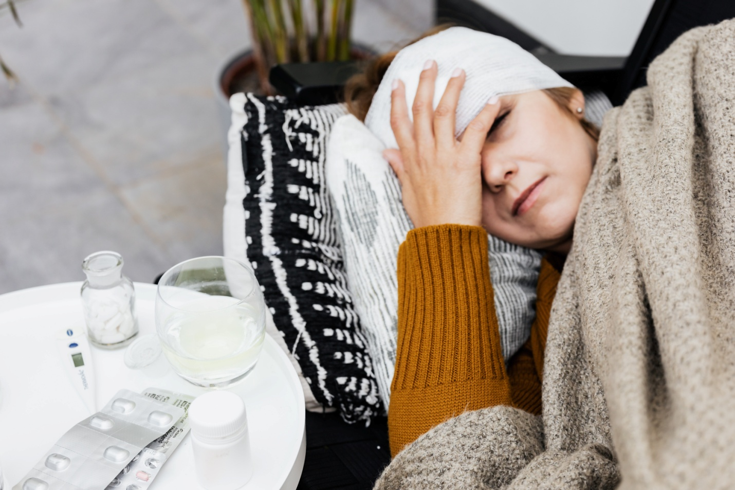 A woman lying on a couch with a bandage around her head