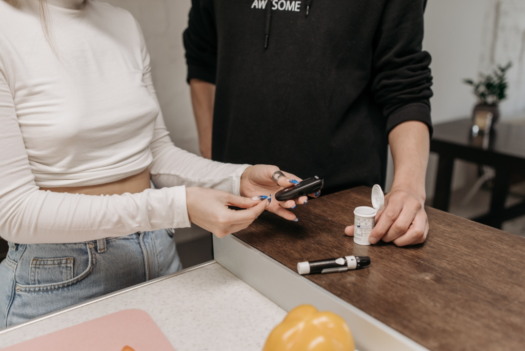 A girl and boy using a glucose meter