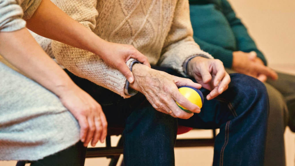 a person holding an elderly man’s hand