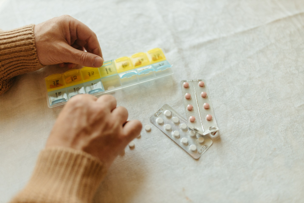 a person putting their meds in a pillbox