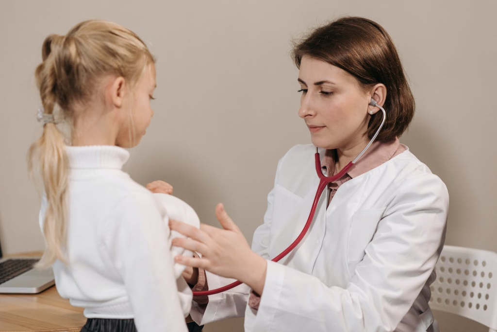 An image of a doctor checking a young girl with a stethoscope