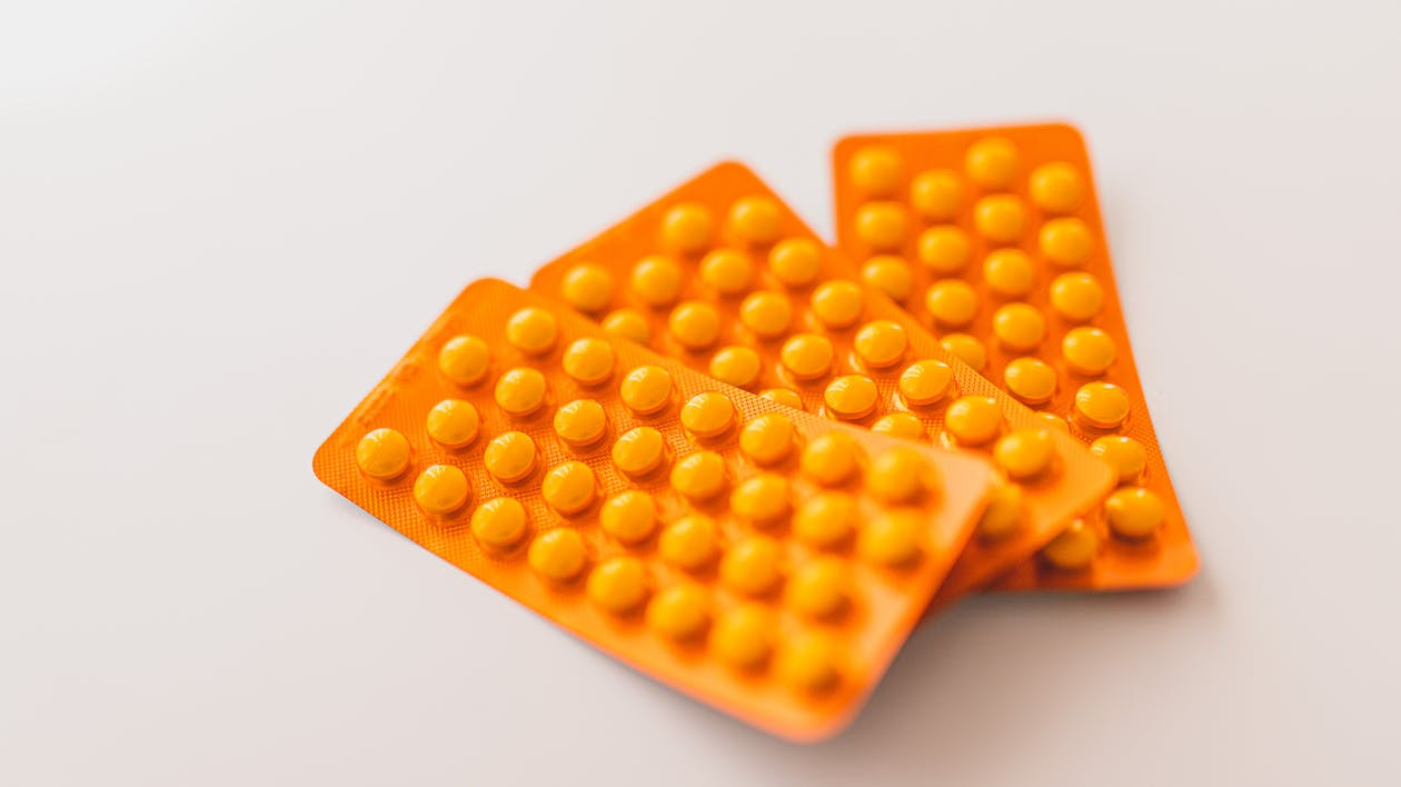 An image of three orange packets of pills 