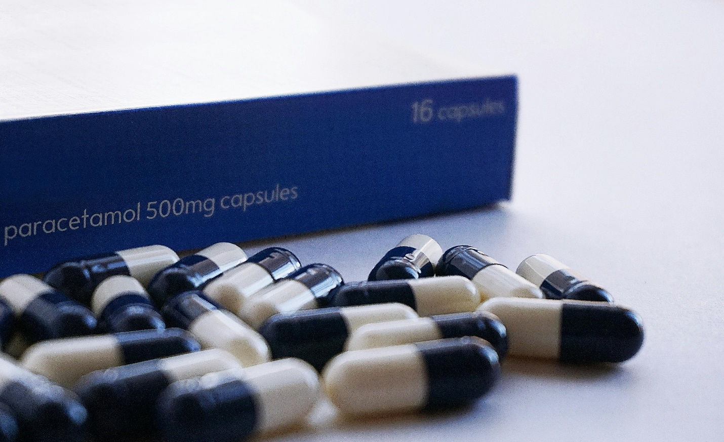 a stack of capsules near the box