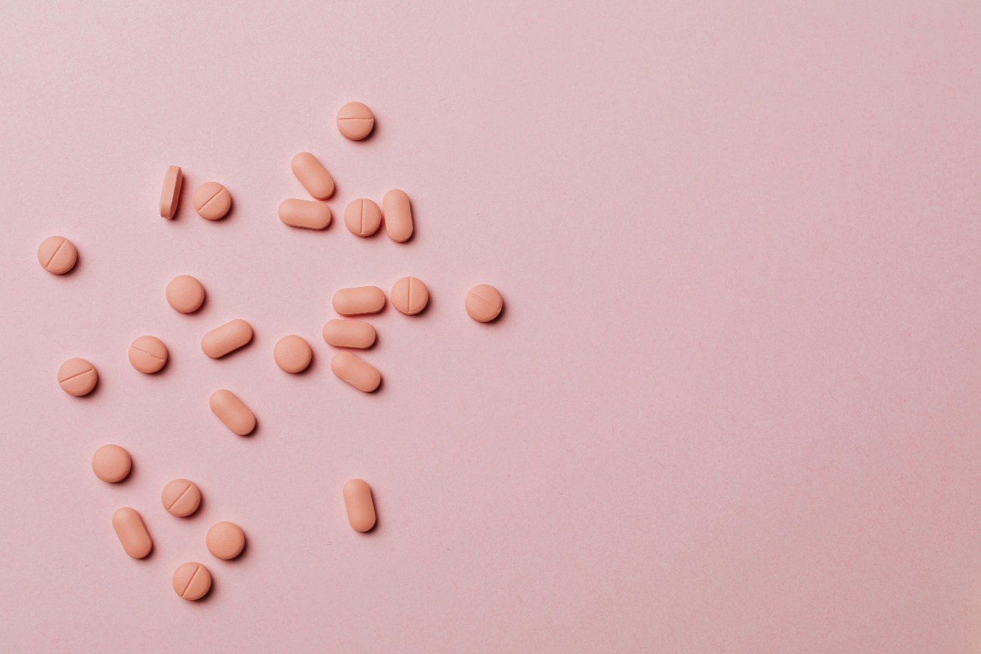 light pink colored pills on a pink background