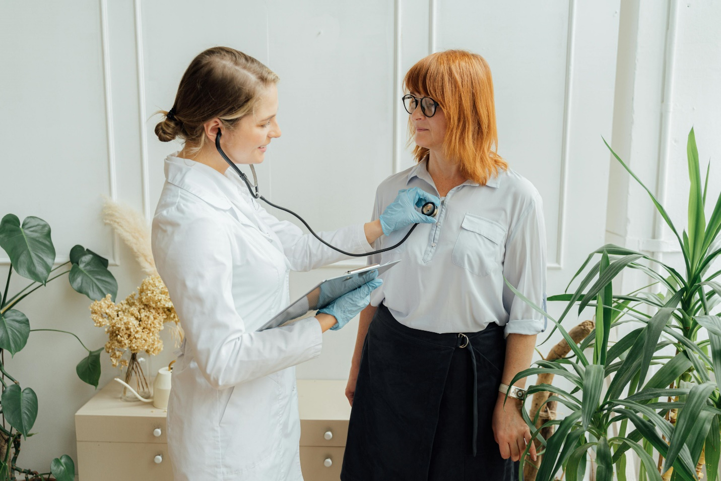 a doctor checking a patient’s heart using a stethoscope