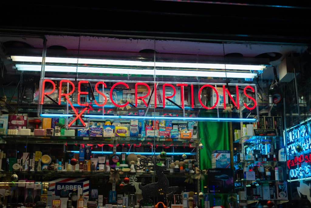 a red neon prescription sign outside of a pharmacy