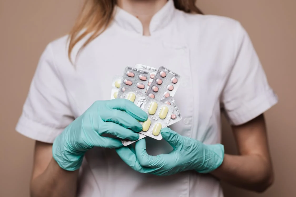 A person holding heart disease medication pills in hand