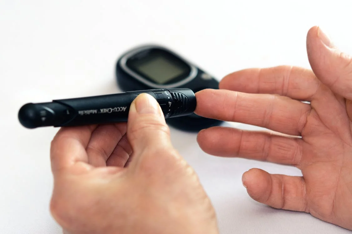 A person checking their blood sugar level with a glucose monitor