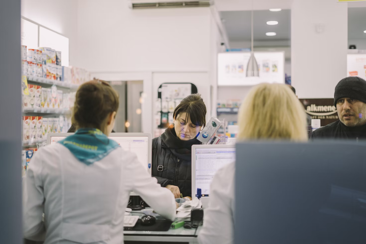 A pharmacist handing a prescription to a patient