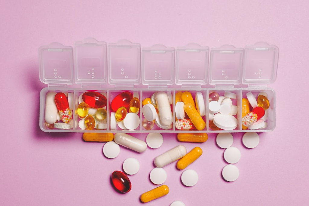 Clear plastic container with red and white medicine capsules.