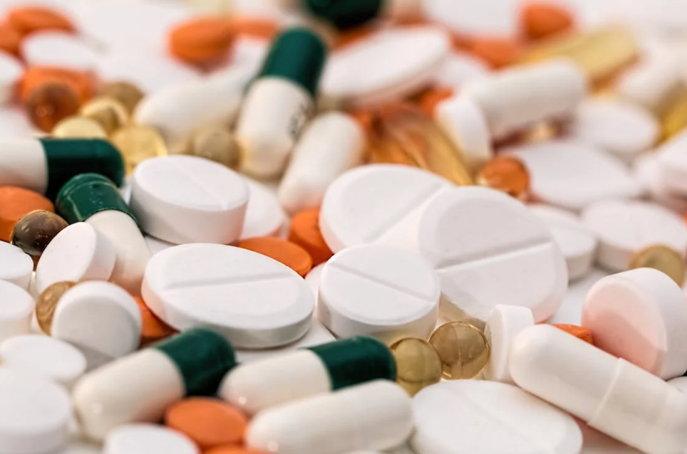 A close-up view of assorted pills and capsules in various shapes, sizes, and colors