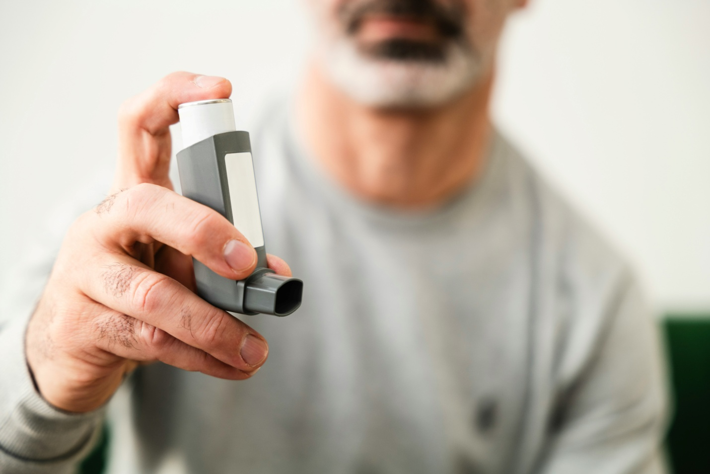image of a man holding an inhaler
