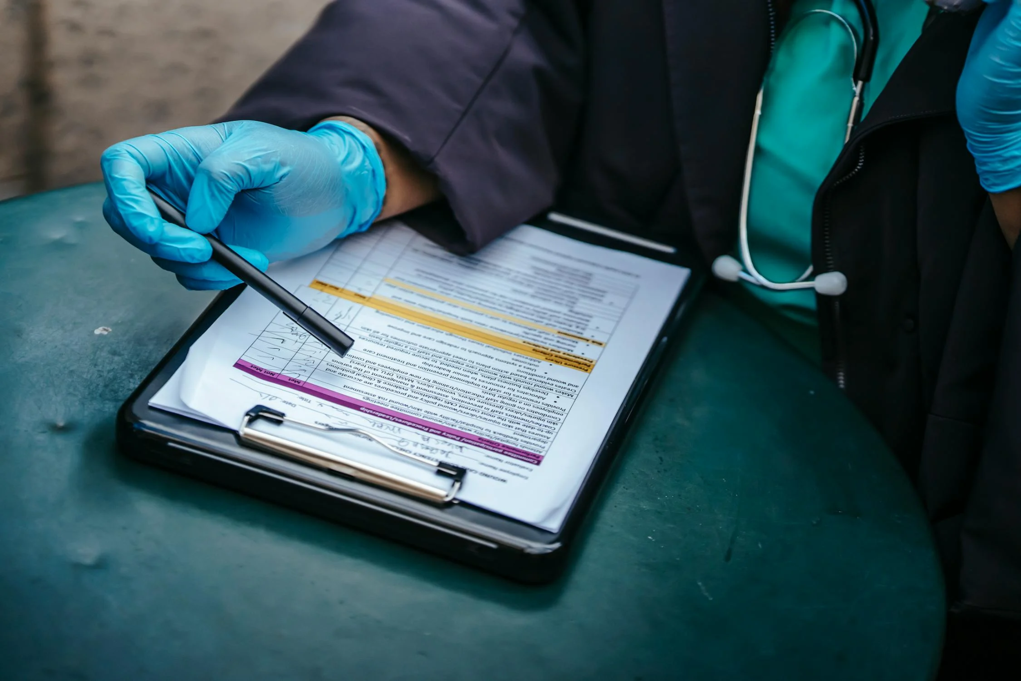 Doctor reviewing a medical form on a clipboard while holding a black pen.