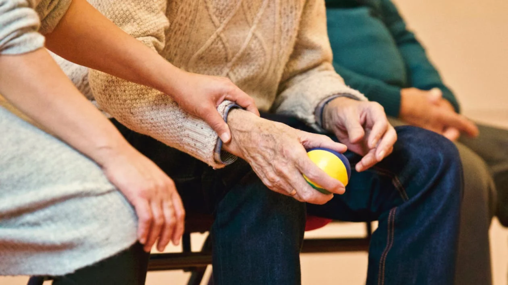 An elderly man holding a stress ball