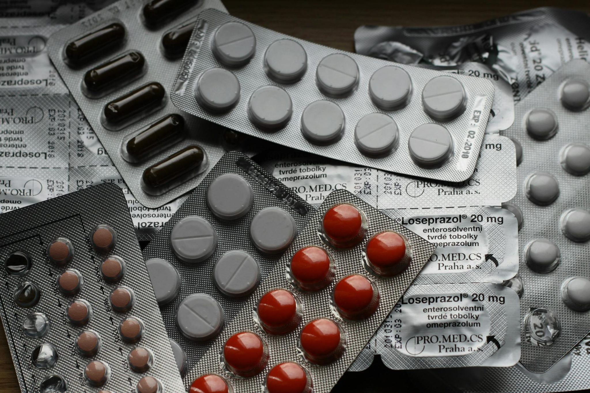 A close-up, high-angle view shows an assortment of pharmaceutical blister packs