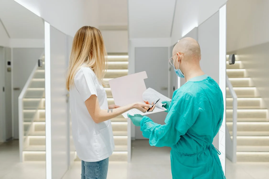 A person reviewing medical documents with a healthcare worker