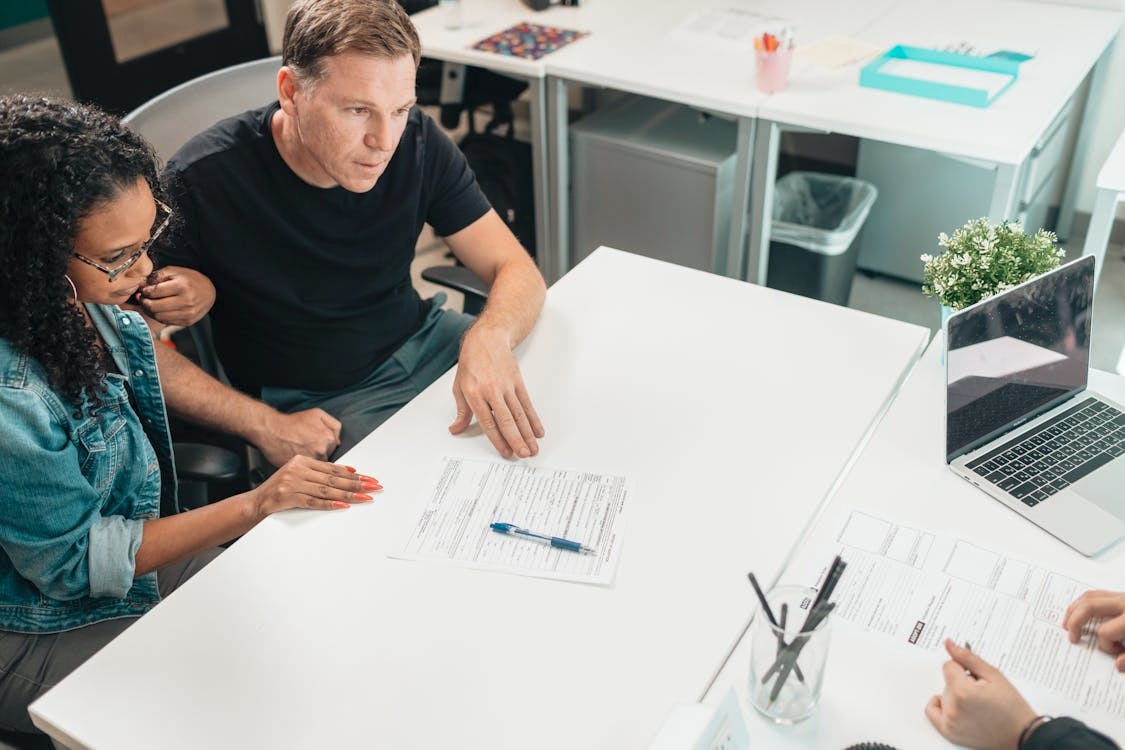 Professional at a desk assisting a patient with paperwork