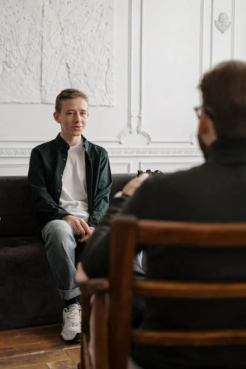 A counselor supporting a young adult during a mental health consultation