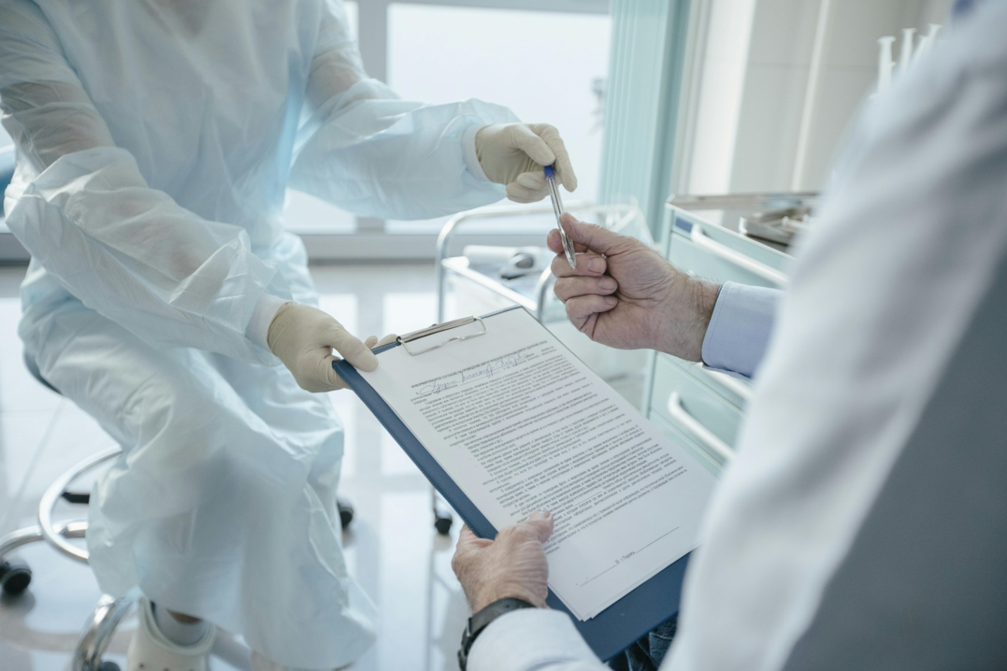 doctor handing documents and a pen