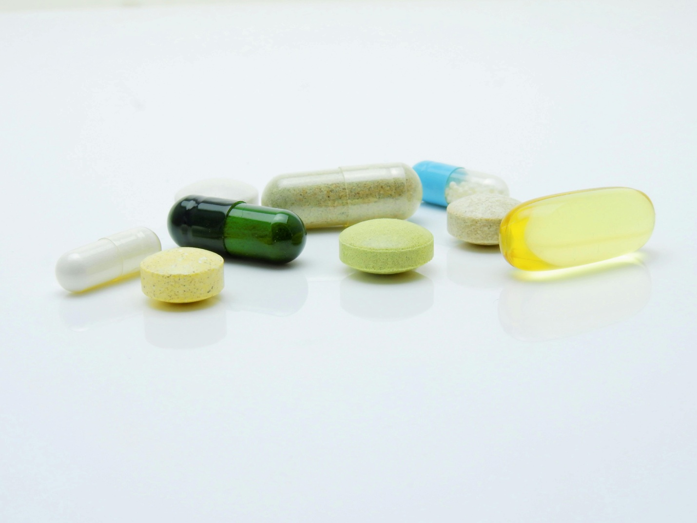 multiple colored pills on a white surface