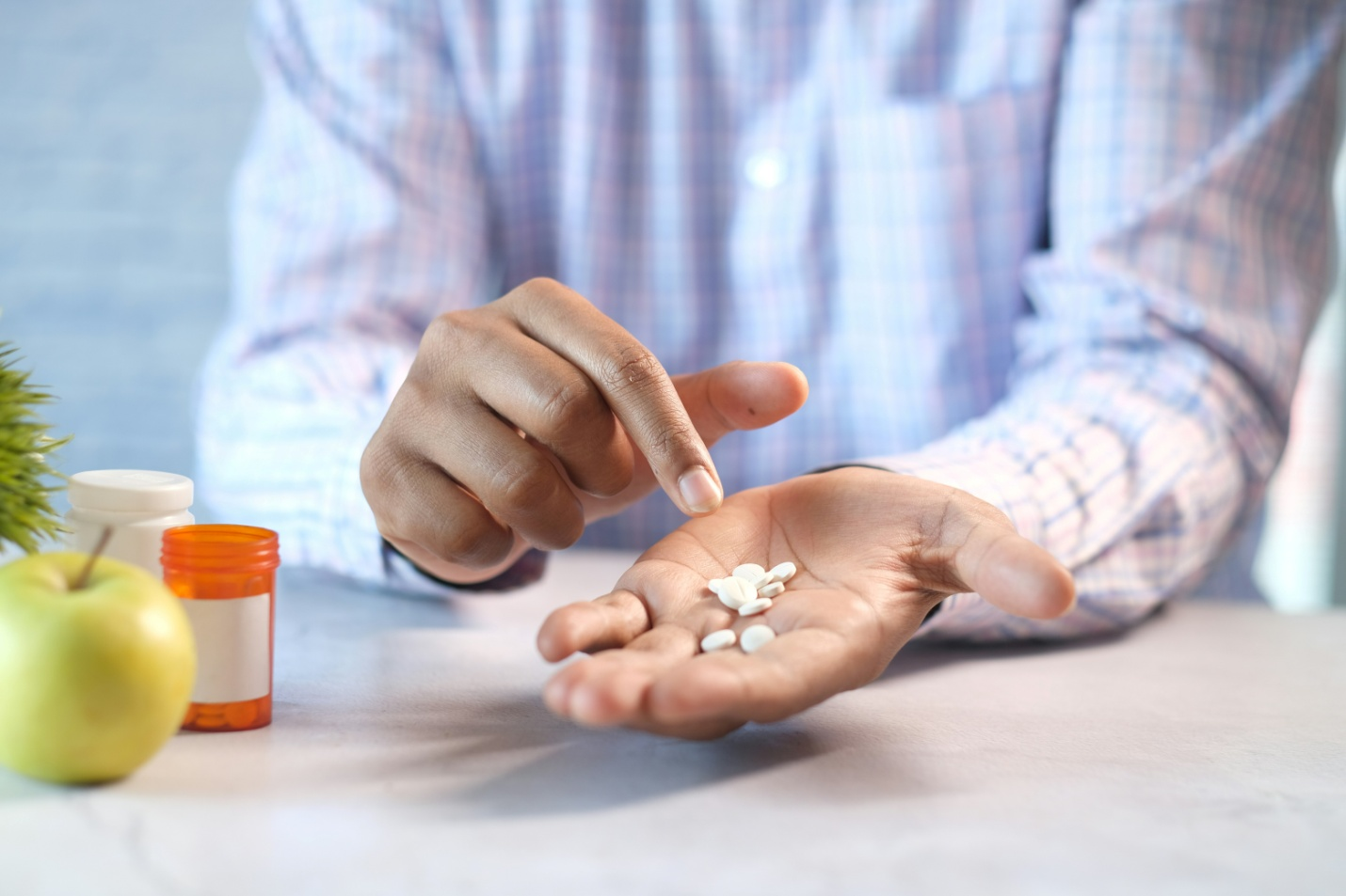 a person counting pills in their hand with the other hand
