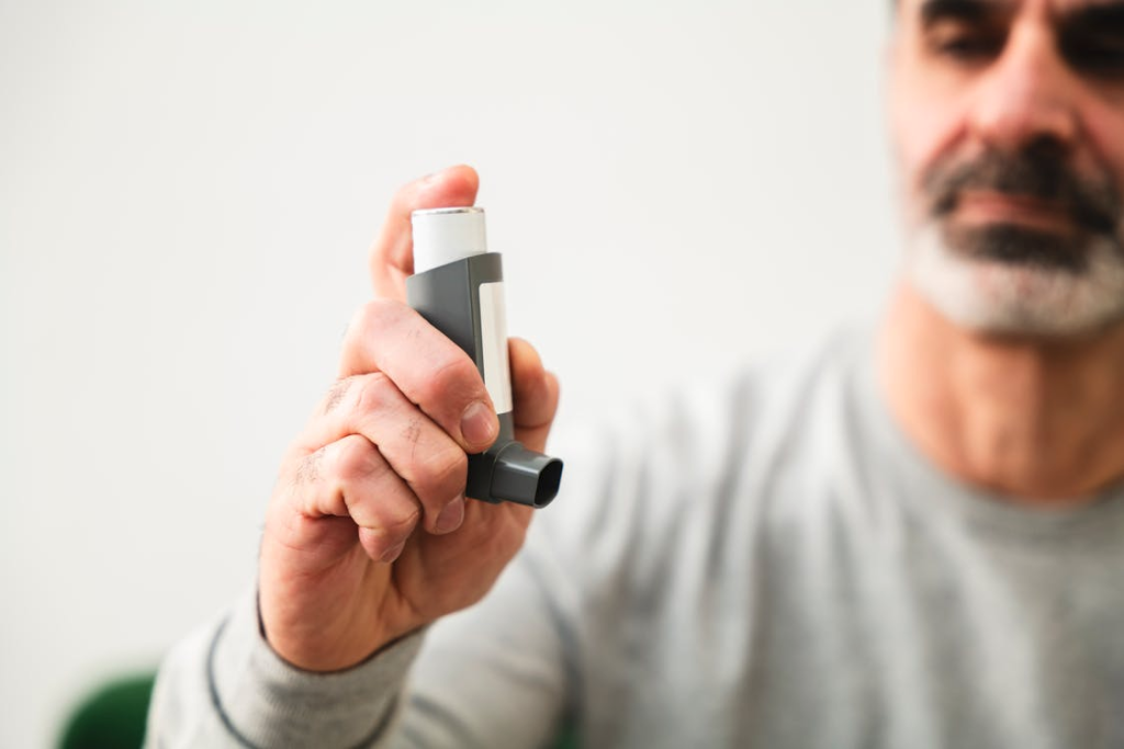A person using an asthma inhaler at home