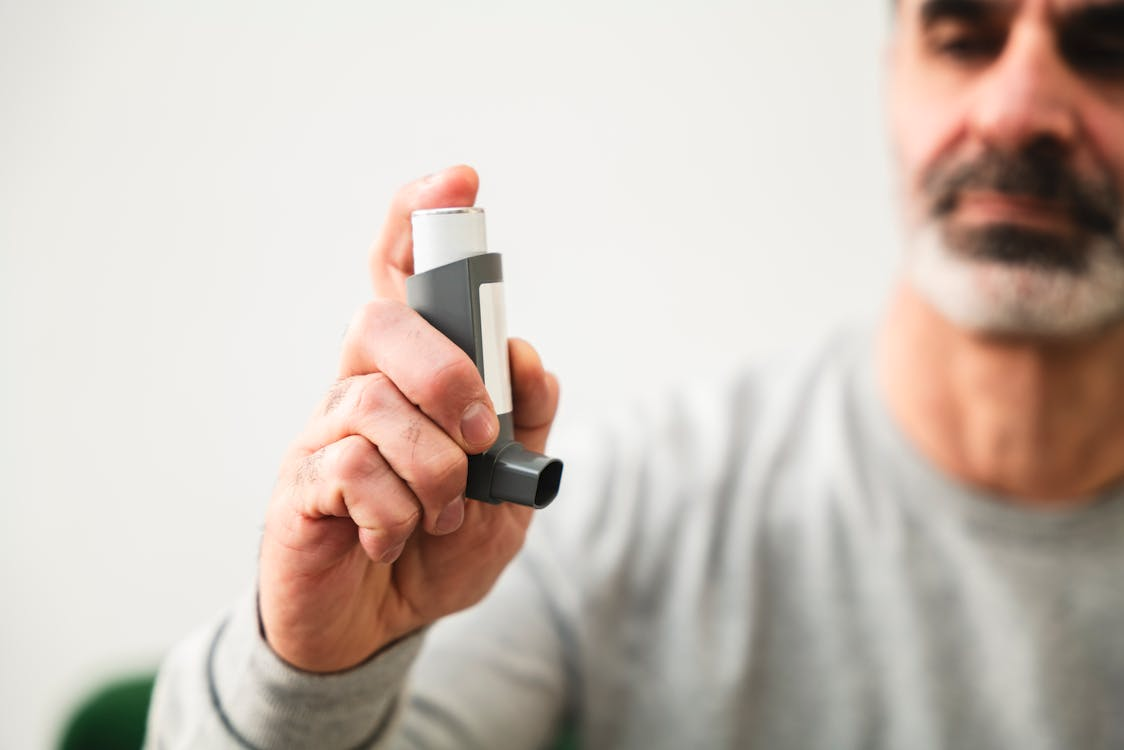 A person using an asthma inhaler at home
