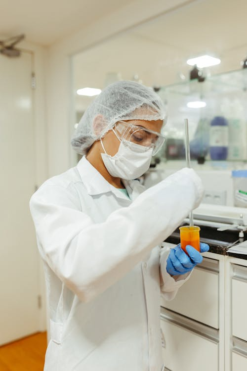 A person working with test tubes and liquid.