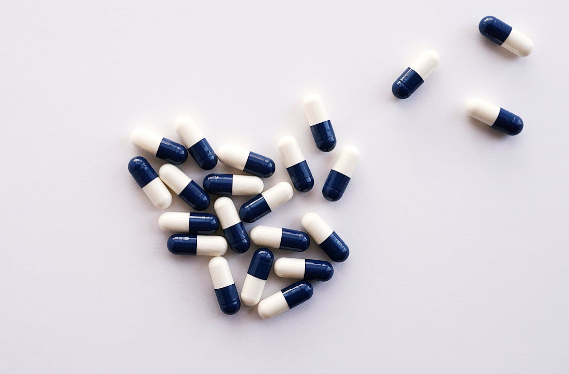 White and black medication pills on a white surface