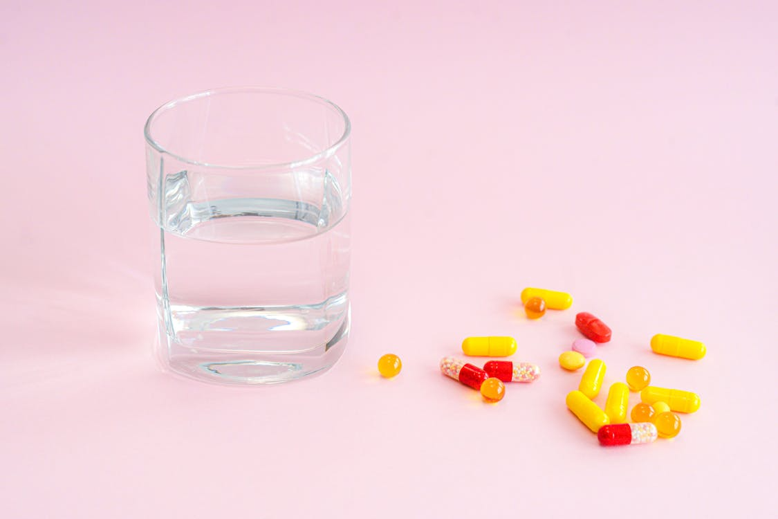 Glass of water beside tablets arranged on a table