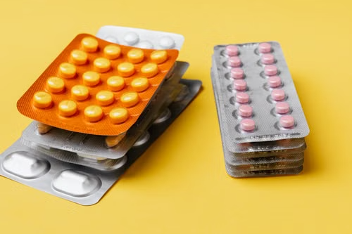 Stack of prescription pills representing medication access.