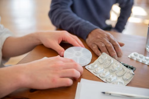 Woman with empty medication blister packs after finishing her prescription