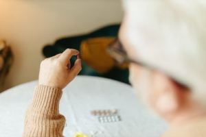 Senior woman holding a prescription pill while managing her medication