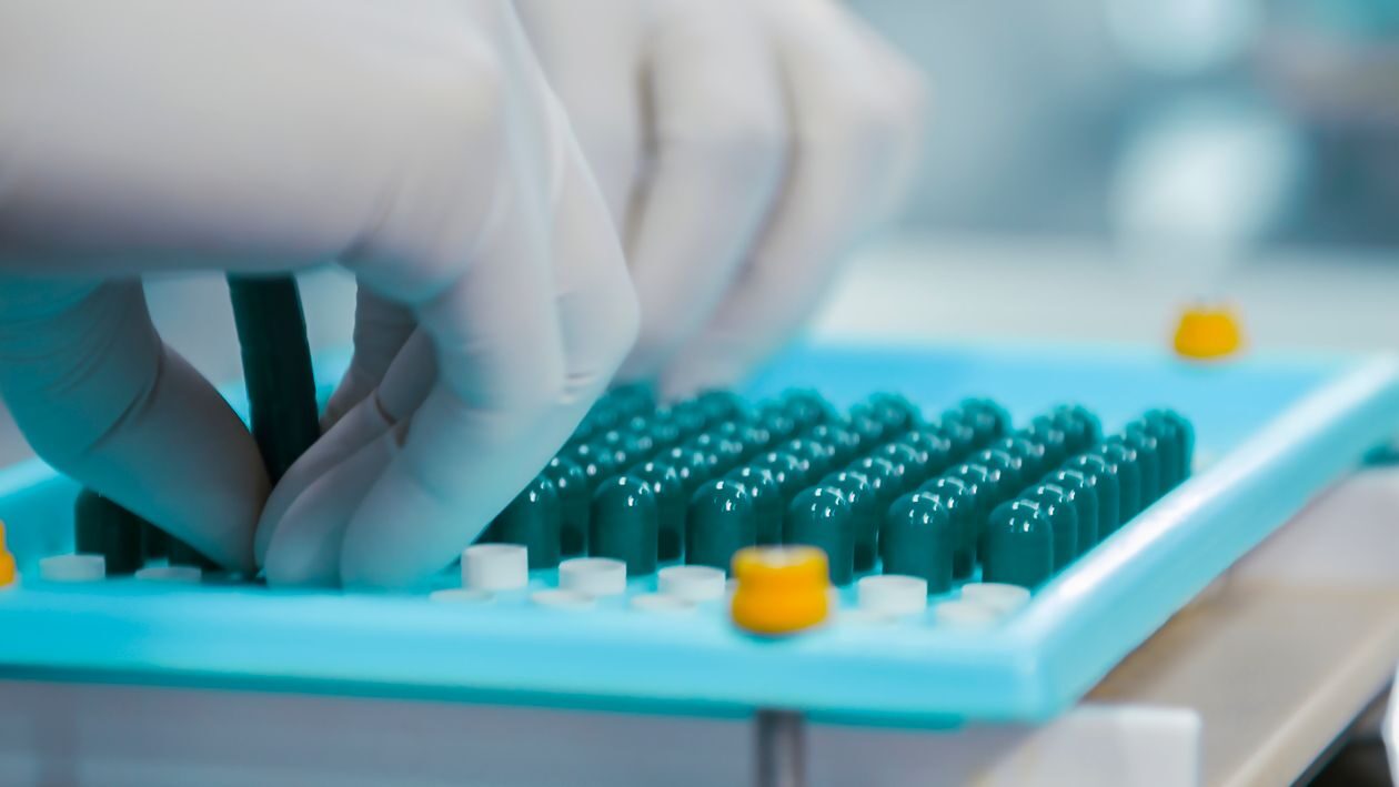 Worker examining medication during the pill manufacturing process