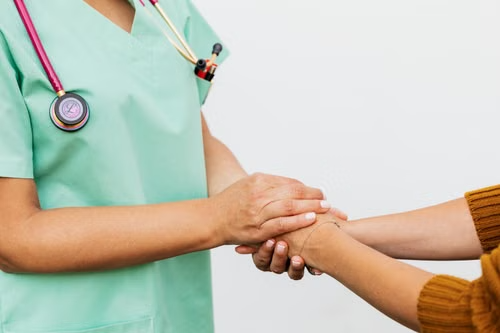 A healthcare advocate or worker holding a patient's hand.