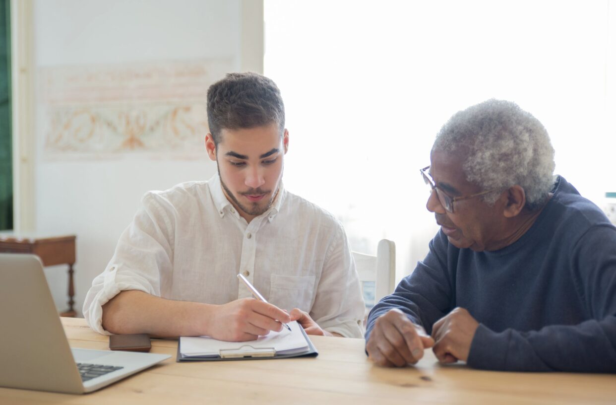 This photo shows a staff member helping an older adult organize documents.