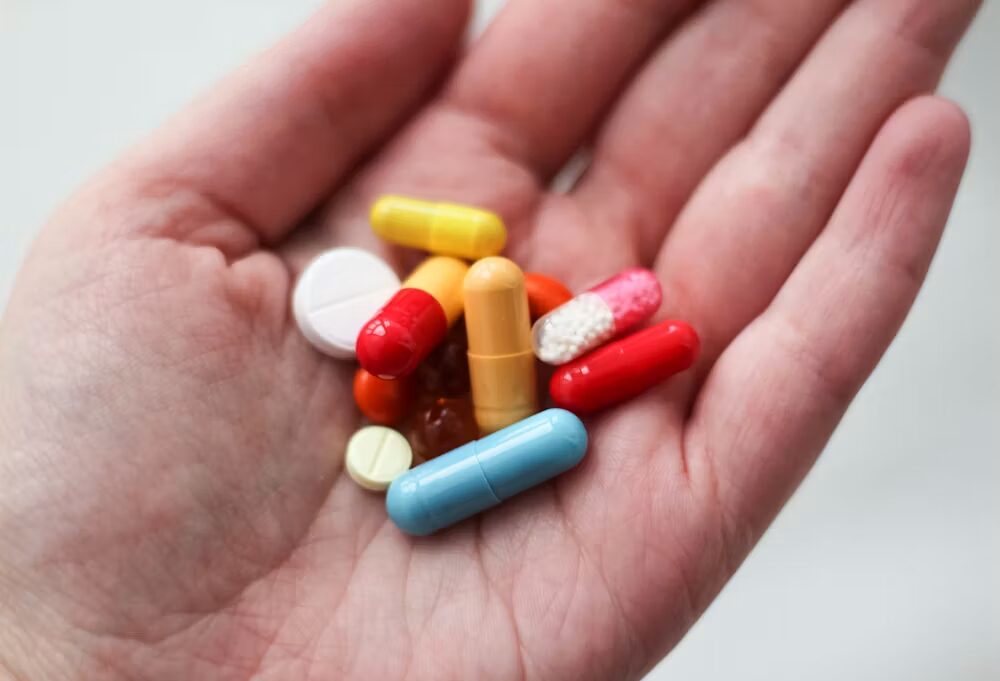A person holding pills in their hand
