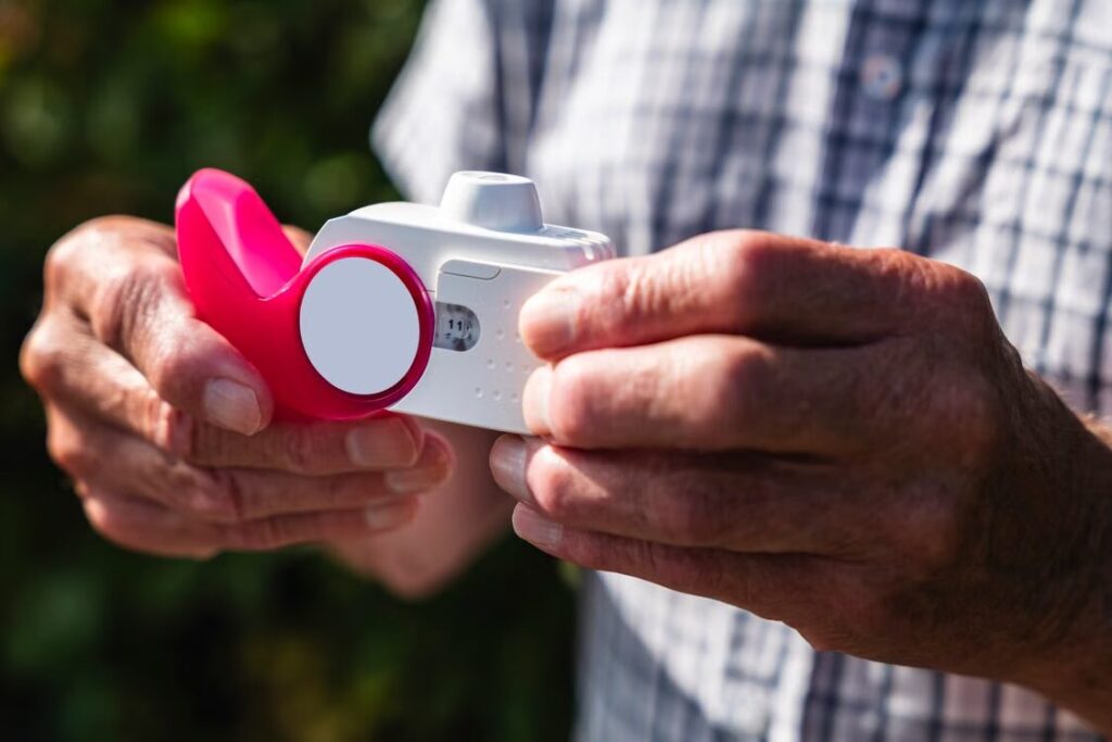 An image of a man holding an inhaler