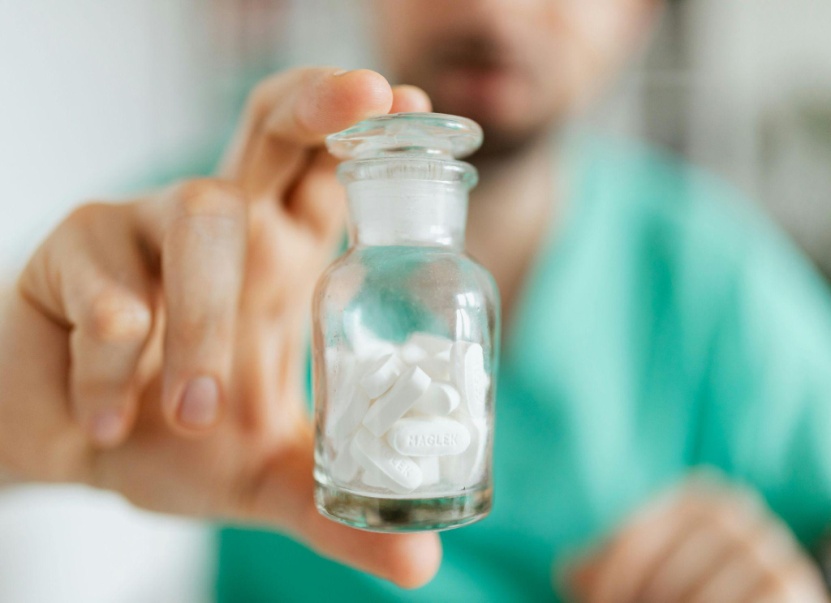 Healthcare professional holding a medication container, representing prescription assistance programs that help eligible patients access needed medications at reduced or no cost.